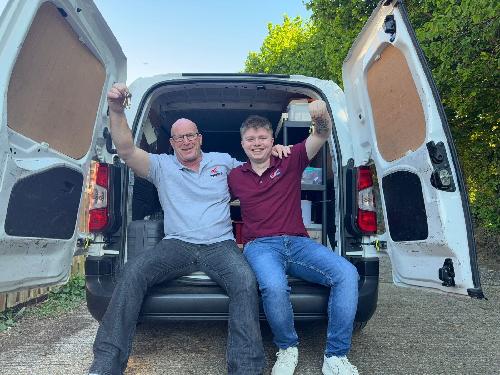Justin and Jay — the father-and-son locksmiths behind Two Keys Security — sitting in the back of their van in Egham, holding up keys